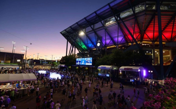 A crowd outside the US Open stadium at night